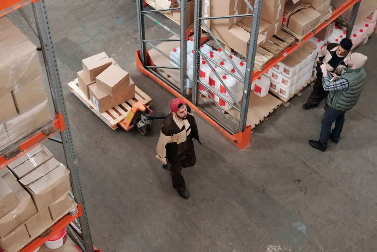 Warehouse team reviewing work among shelves of freight